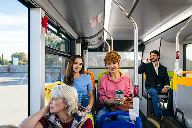 istock Commuters riding city bus, smiling at camera 2244745488