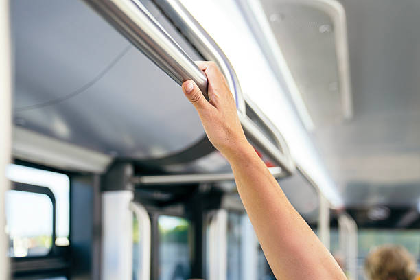 istock Passenger holding onto handrail inside public city bus 2244746085