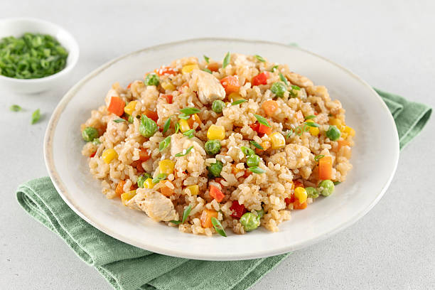 istock Fried rice with chicken and vegetables carrots ,peppers, corn, green peas on white background. 2244746186