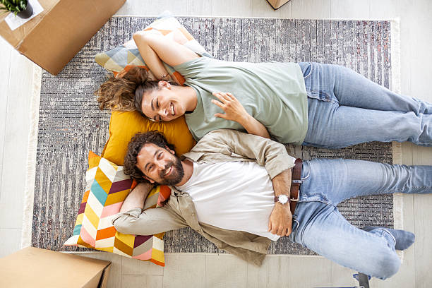 istock Young Pair Taking a Moment to Relax Among Moving Boxes 2244746238