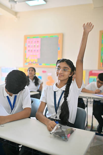 istock Indian schoolgirl raising hand in classroom 2244750868