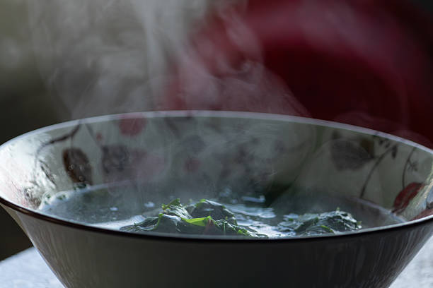 A macro shot of a fresh, homemade hot soup with beautiful steam rising. Concept of comfort food, cold weather, or healthy eating.