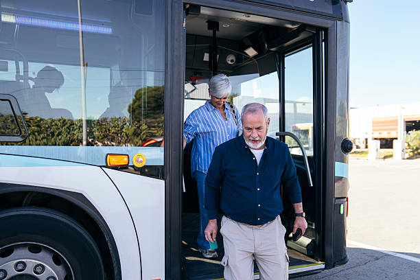 istock Senior couple disembarking city bus using public transport 2244751045
