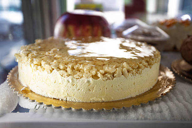 Cheesecake with a shiny glaze and crumbly topping displayed in a chilled bakery counter, ready for sale