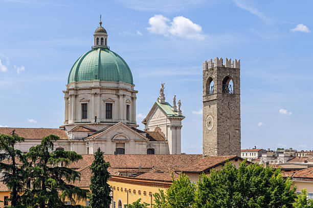 istock Authentic Brescia view with Duomo Nuovo dome and bell tower among trees rooftops under bright light 2244757659