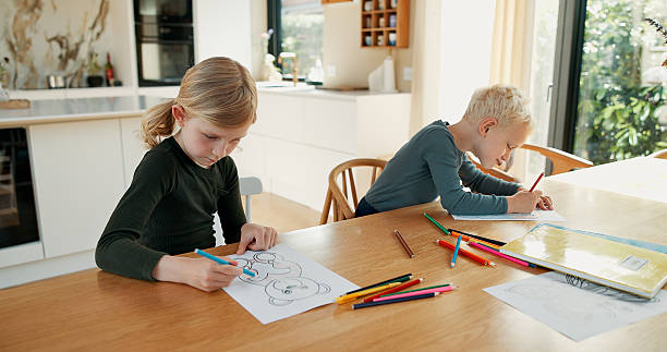 istock Homework, kids and siblings with creativity, drawing or learning with knowledge. Child development, apartment or girl with boy, color or education with artistic project, hobby or fine motor skills 2244759232