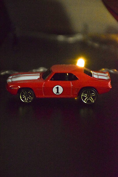 istock Bright red toy car with racing number one displayed on a dark surface, showcasing vibrant colors and intricate details, perfect for automotive enthusiasts and collectors 2244767654