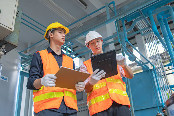 istock Two workers review safety protocols in a factory emphasizing teamwork and efficiency. 2244769244