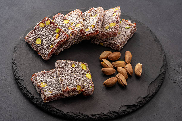 istock Turkish delight cezerye with pistachio or hazelnut on black background. Cezerye, a traditional dessert from the Mersin region 2244769846