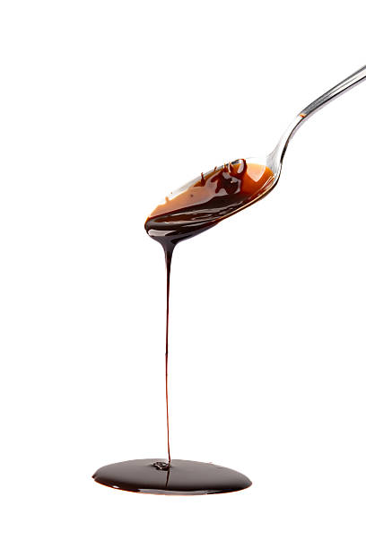 istock Melted chocolate or chocolate sauce dripping from a metal spoon 2244770074