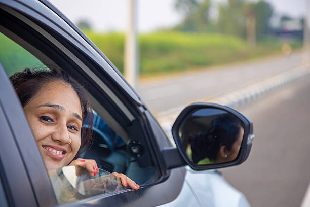 istock Smiling Woman Leaning From Car Window On Open Road During A Drive 2244771602