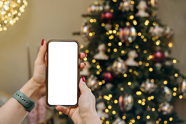 istock Mockup woman's hand holding using smart phone with white blank screen at Christmas light background, mobile app design and advertising, online marketing 2244774115