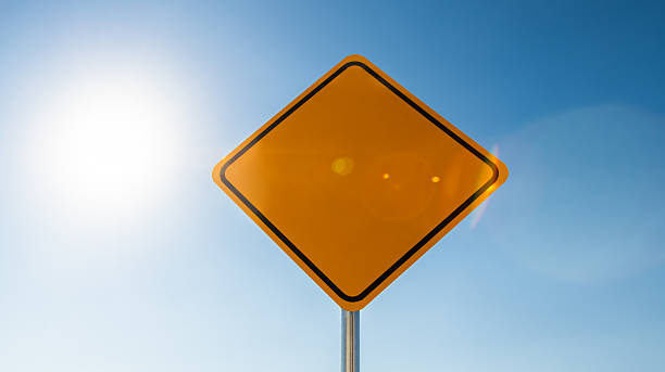 istock Blank yellow road warning sign against clear blue sky background 2244775637