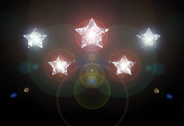 Bright five stars with glowing lights and lens flares on a black background.