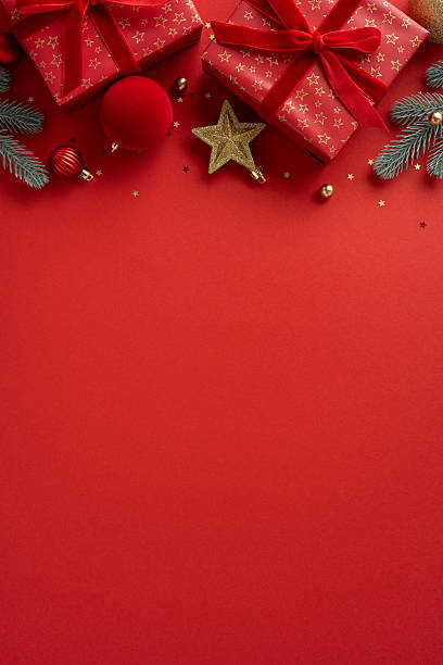 istock A vertical red backdrop features wrapped gifts, gold ornaments, and pine branches creating a festive mood for Christmas and New Year celebrations 2244780456