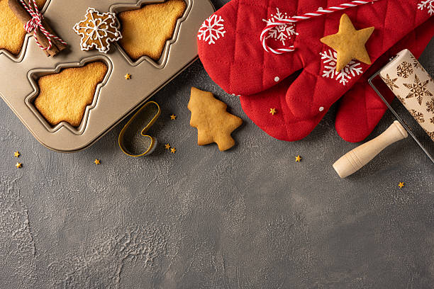 istock A top view cozy Christmas baking scene featuring shaped cookies, a muffin tin, dough, rolling pin, and festive red mittens with snowflake patterns. Perfect for holiday treats, gifts 2244780567
