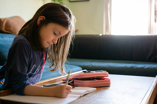 istock Young girl concentrating on writing homework at home 2244780696