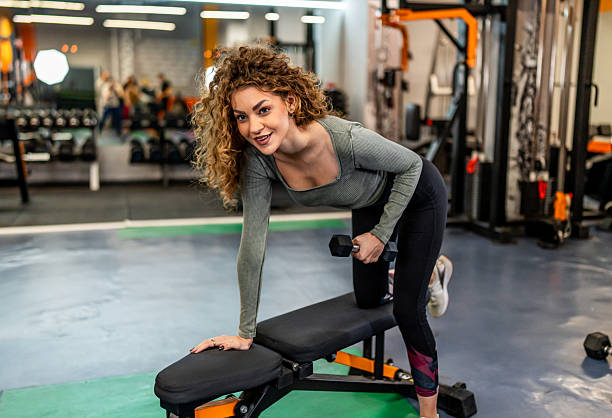 istock Woman doing dumbbell row exercise in gym smiling 2244781728