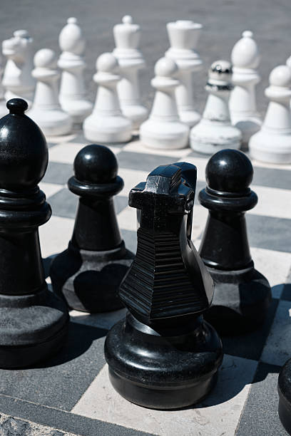 istock Large chess pieces on outdoor board symbolizing competition and strategy. 2244783445