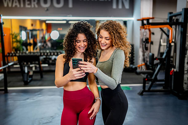 istock Women friends using smartphone during gym workout 2244783886
