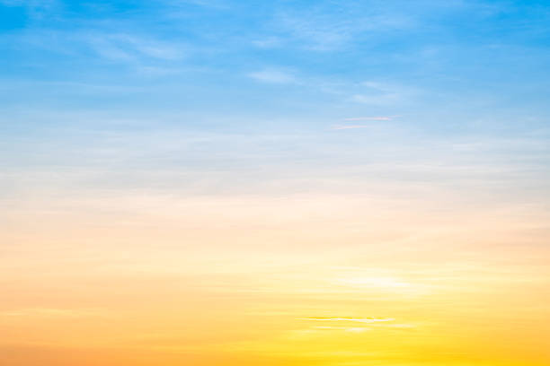 Sunset or sunrise sky with a vibrant gradient of orange, gold, and soft blue. Clear atmosphere with wispy clouds. Peaceful, natural light background. hope, freedom, new day and inspirational Concepts