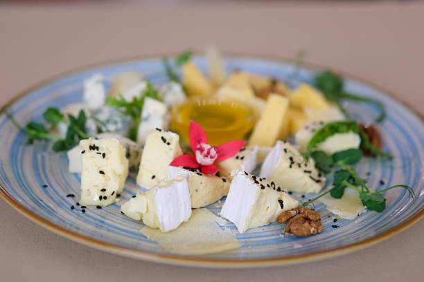 istock Cheese plate with grapes and nuts on wooden table, top view 2244787215