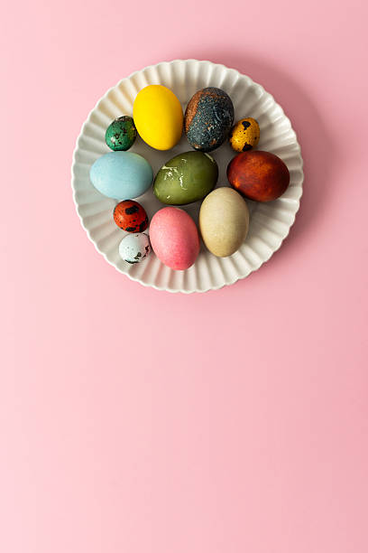 istock A variety of decorated Easter eggs are arranged on a circular plate against a soft pink background, showcasing vibrant colors and intricate designs for a seasonal celebration 2244789142