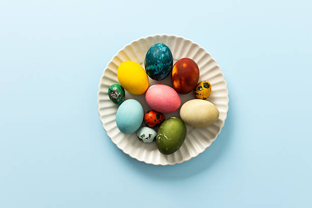 istock Beautifully decorated Easter eggs in vibrant colors are displayed on a white plate against a light blue background, symbolizing the joy of Easter festivities 2244789148