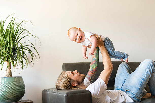 istock father playing with baby daughter on sofa at home 2244791898