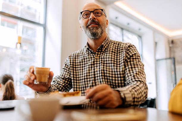 istock Casually clothed mature man having coffee and cake at cafe 2244792155