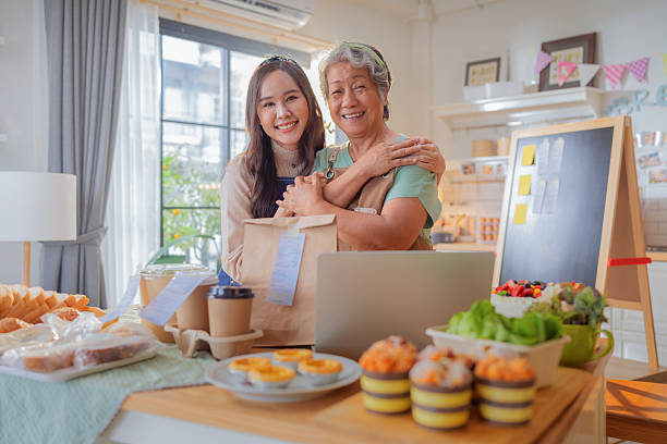 Bakery shop Asian senior woman with apron working in bakery pastry store shop checking order for delivery online purchase small business shopstore woman working in bread bakery store