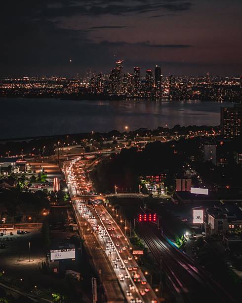 Nighttime cityscape of Toronto with illuminated highways and skyline, showcasing the vibrant urban life and architecture.