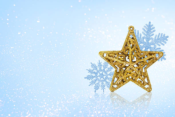 Christmas blue background with Christmas tree decorations with a silver snowflake and golden star and golden lights with copy space. New Year and Christmas card. Banner