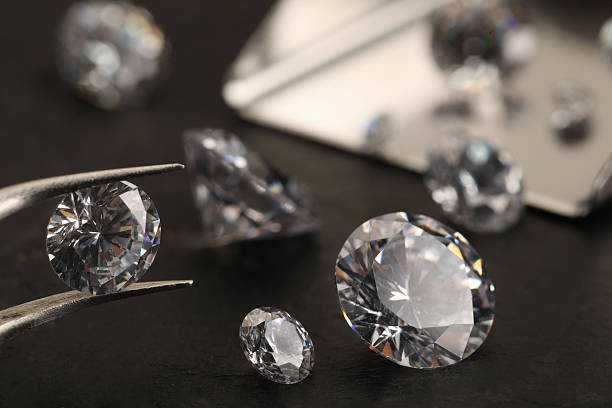 istock Tweezers with beautiful gemstones on black table, selective focus 2244796256