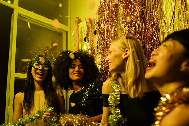 Photo of a group of female friends celebrating the coming of a New Year's, together on a house party