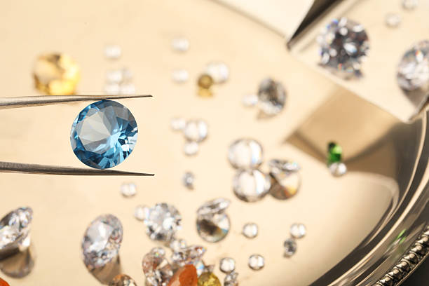 istock Tweezers with beautiful gemstone on blurred background, closeup 2244797421