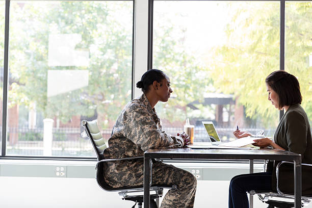 istock Military member and professional discuss work during an indoor meeting. 2244799480