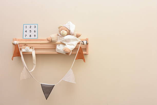 a shelf with a rag doll and a wooden toy camera