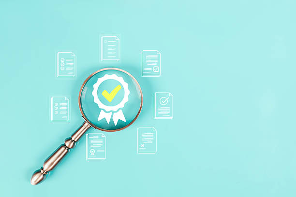istock Magnifying glass focusing on a certification badge with check mark surrounded by document icons on turquoise background, symbolizing quality assurance, audit, verified standards, business concept. 2244802833