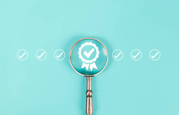 istock Magnifying glass focusing on a check mark and quality badge icon, symbolizing quality assurance, certification, and verified standards concept on turquoise background for business success. 2244802841