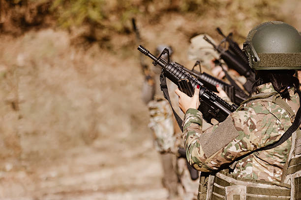 istock A female soldier holds a rifle during a team exercise. 2244805508