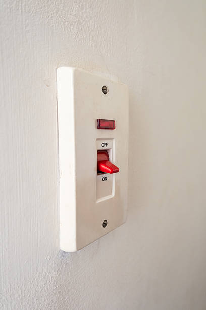 istock A close-up of a white light switch on a plain wall. The switch is red and labeled with 'ON' and 'OFF' indicators. Simple and functional design. 2244805777