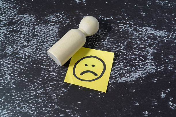 Sad emoji on a yellow color sticky note