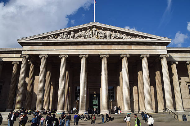 British Museum, London, England - November 7th 2023:  Facade of the British Museum with Union Jack against a blue sky