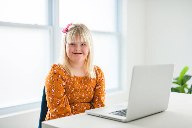 istock Girl with Down Syndrome doing homework at home, getting ready to go back to school 2244810711