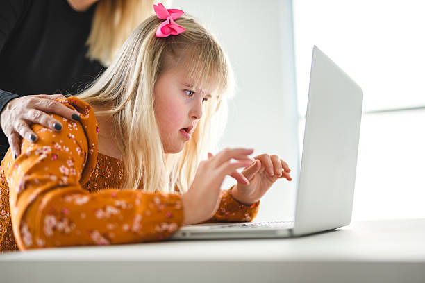 istock Girl with Down Syndrome doing homework at home, getting ready to go back to school 2244810733