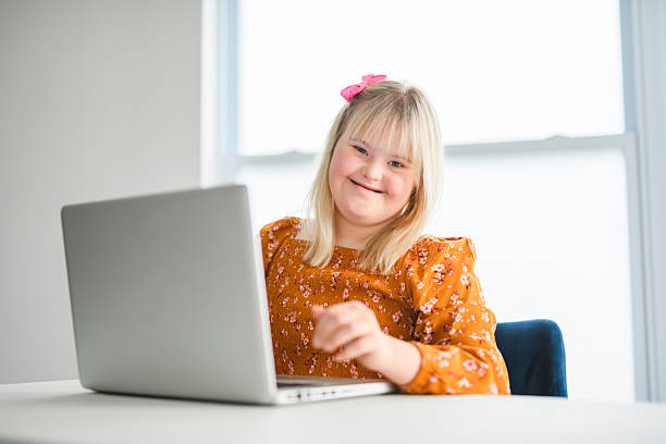 istock Girl with Down Syndrome doing homework at home, getting ready to go back to school 2244810742