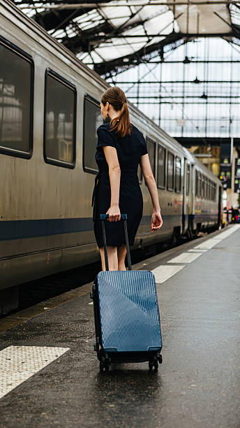 istock A woman with luggage on a train platform. 2244811348