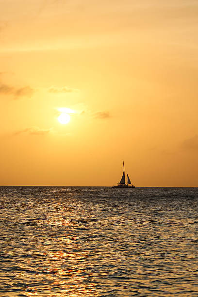 istock sunset in Aruba with a sailboat on the horizon. 2244815097