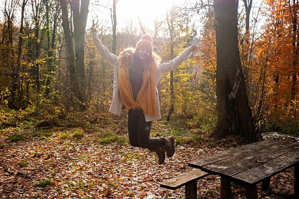 Woman throwing autumn leaves in the air